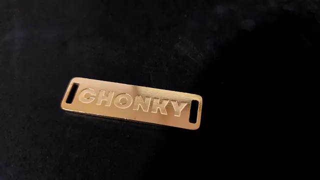 Polished brass slot label with raised lettering